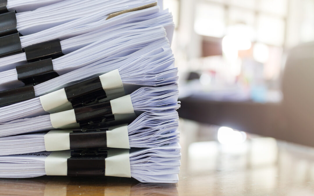 large stack of documents sitting on a desk